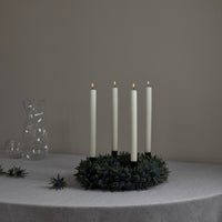 black candle sticks on xmas wreath with candles